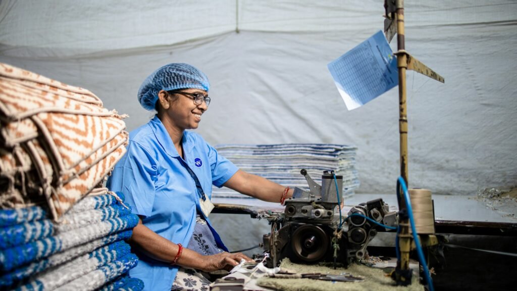 Woman working with textile production equipment in a small manufacturing business, illustrating women-led MSMEs in India